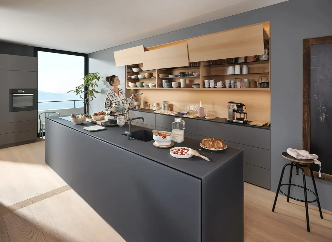 Thiết kế bếp Blum hiện đại với tủ bếp màu xám, đảo bếp, tủ gỗ treo và tay nâng Blum